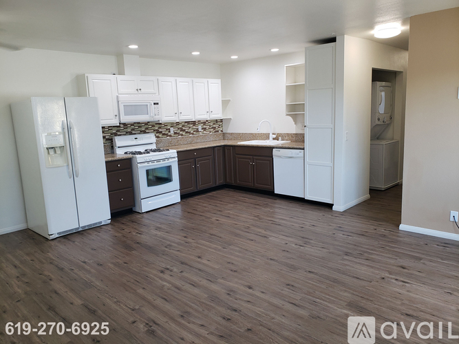 A kitchen with white appliances and cabinets is on the market.