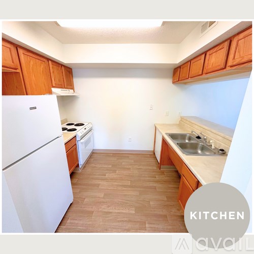 A kitchen with wooden cabinets and a white refrigerator.