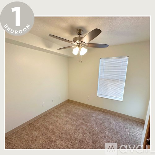 A bedroom with a ceiling fan and a window with blinds.