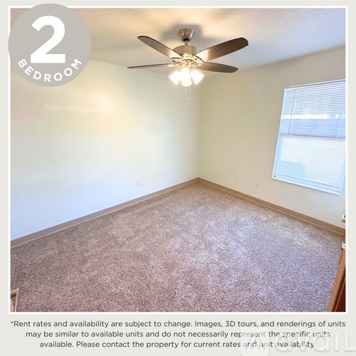 A bedroom with a ceiling fan and a window.