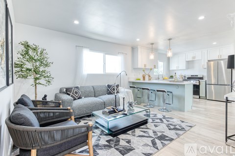 A modern living room with a grey sofa and a glass coffee table.