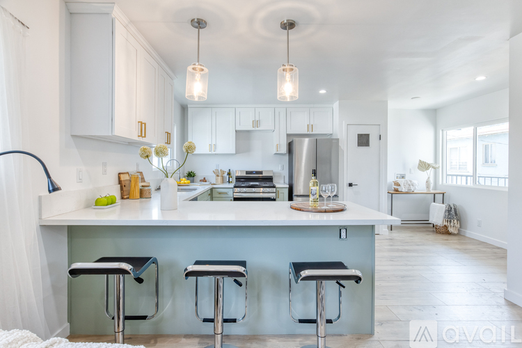 A kitchen with a blue island and white cabinets.