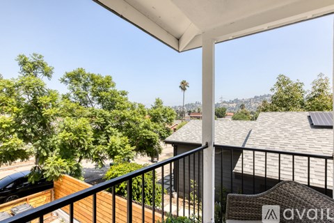 A balcony with a view of the city and trees.