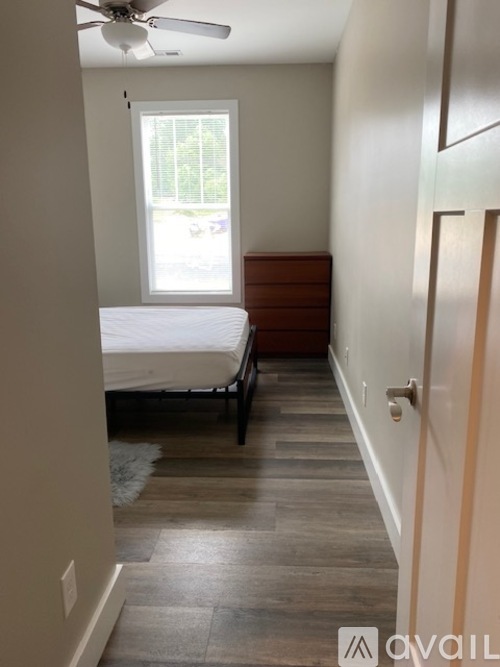A bedroom with a bed and a window.