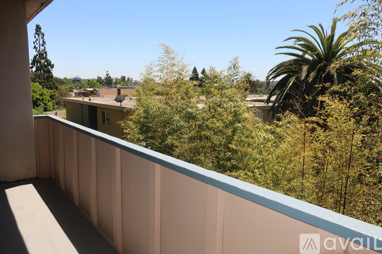 A balcony with a view of trees and houses.