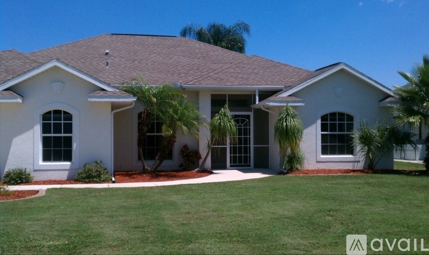 A house with a brown roof and white walls is for sale.