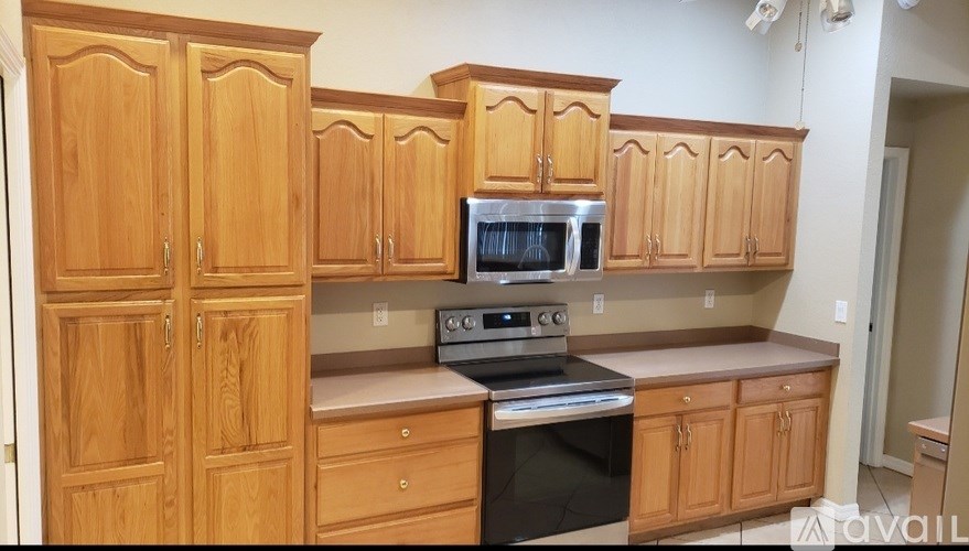A kitchen with wooden cabinets and a stainless steel oven.