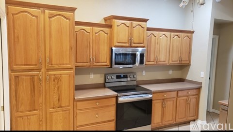A kitchen with wooden cabinets and a stainless steel oven.
