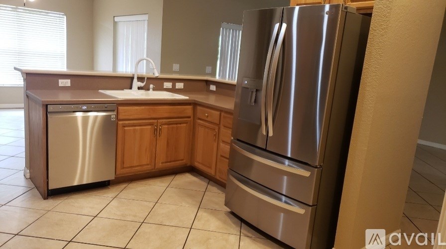 A kitchen with a stainless steel refrigerator and a sink.