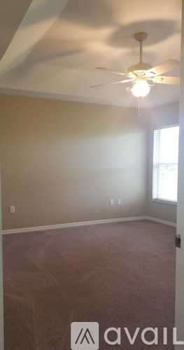 A room with a ceiling fan and a window.