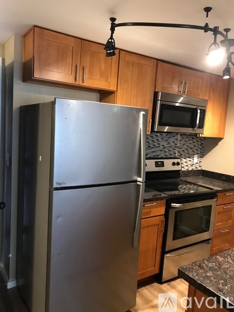 A kitchen with a stainless steel refrigerator and microwave above the stove.