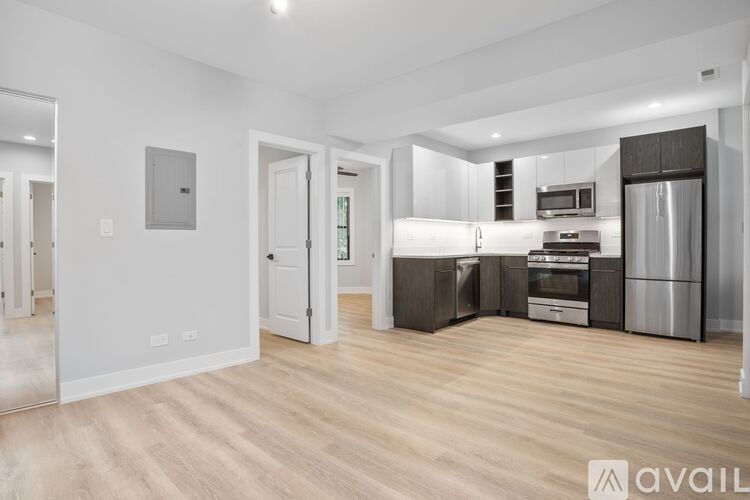 A spacious kitchen with stainless steel appliances and wooden flooring.