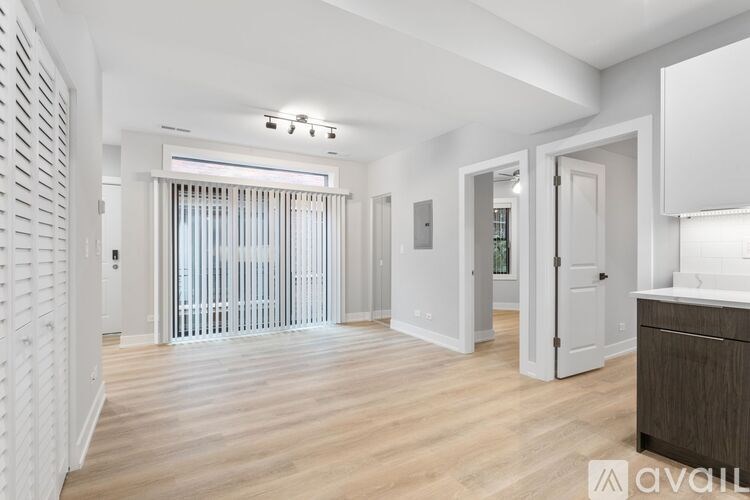 A spacious room with wooden flooring and white walls.