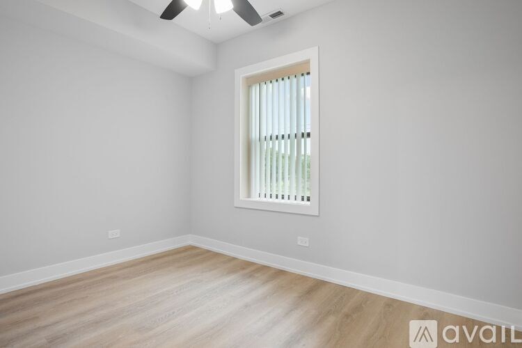 A room with a window covered by a white blind.