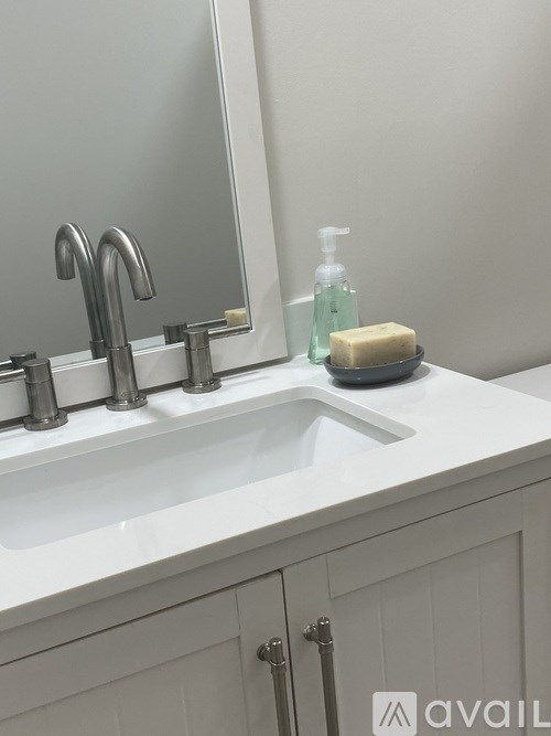 A white sink with a soap dish and a soap bar on it.