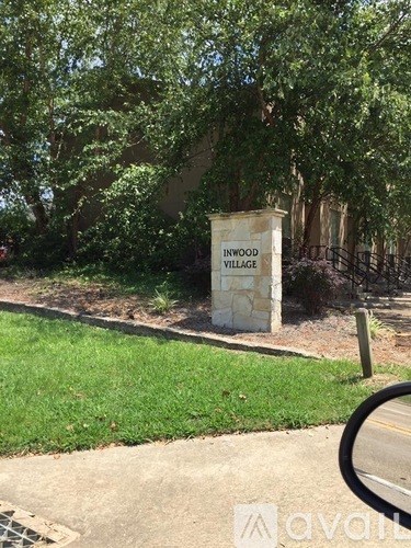 A sign that says "Inwood Village" stands in a grassy area.