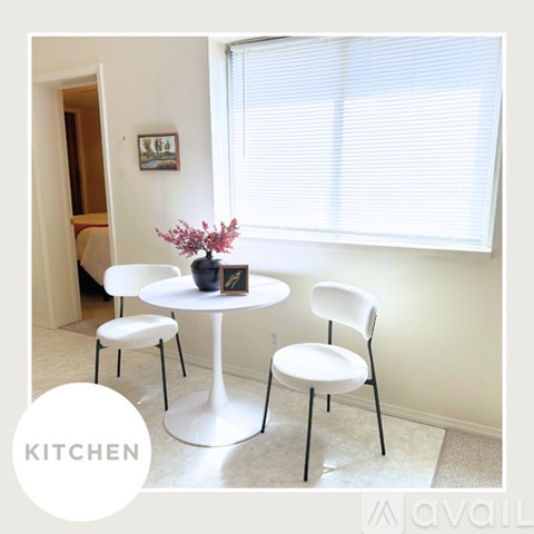 A white table with three chairs and a vase of flowers on it.