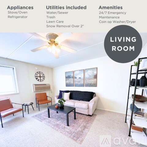 A living room with a sofa, chairs, and a ceiling fan.