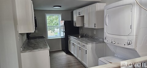 A kitchen with white cabinets and appliances.