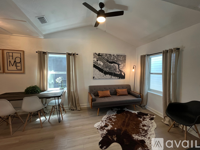 A living room with a couch, chairs, and a rug.