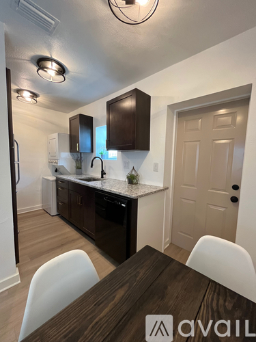 A kitchen with a table and chairs in front of it.