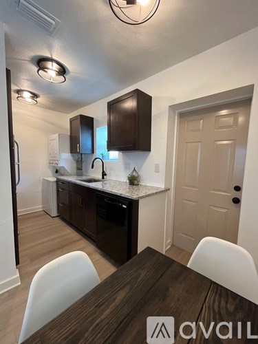 A kitchen with a table and chairs in front of it.