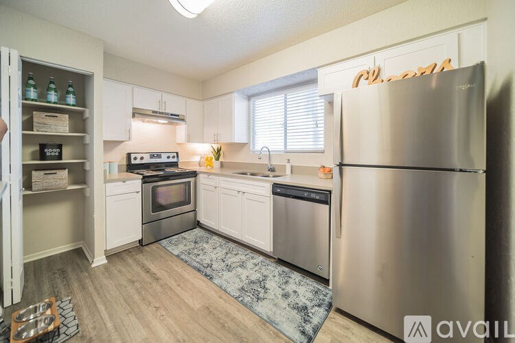 A kitchen with a refrigerator, oven, and sink.