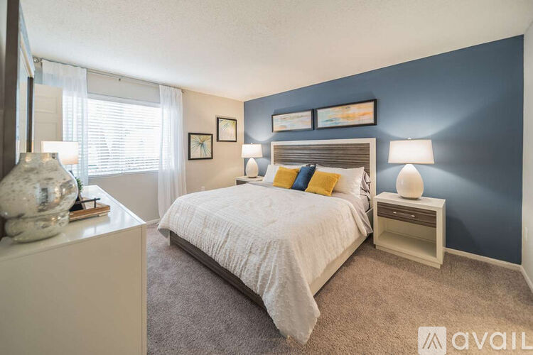 A bedroom with a white bed and a blue wall.