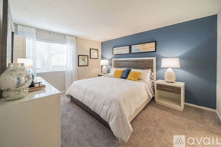 A bedroom with a white bed and a blue wall.
