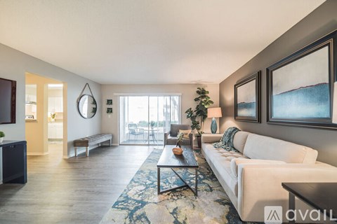 A living room with a white couch and a rug.