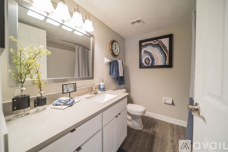 A bathroom with a white counter top and a white toilet.