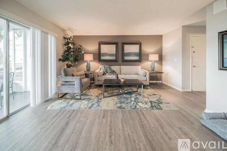 A living room with a grey sofa, a coffee table, and a rug.