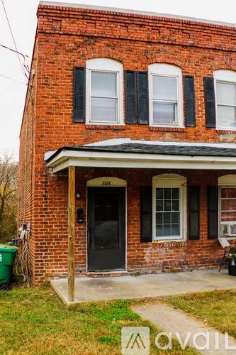 A red brick house with a black door and windows.