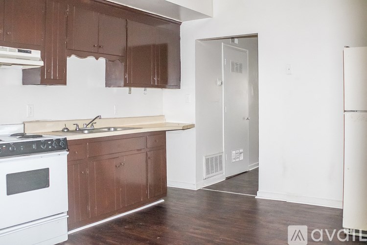 A kitchen with brown cabinets and a white stove.