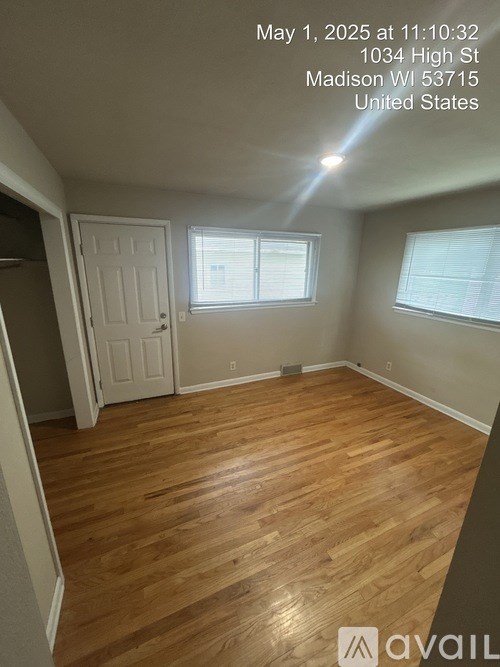 A room with wooden flooring and a window with blinds.