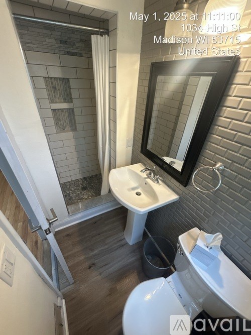 A bathroom with a white toilet, a sink, and a mirror.