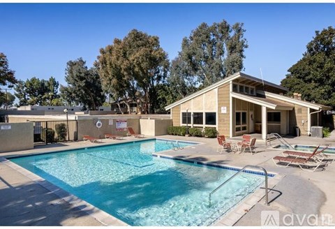 A large outdoor swimming pool with a house in the background.