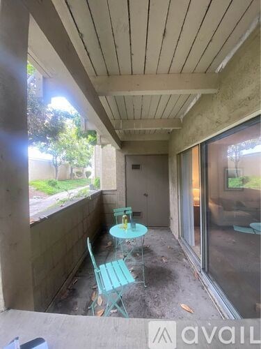 A balcony with a table and two chairs.
