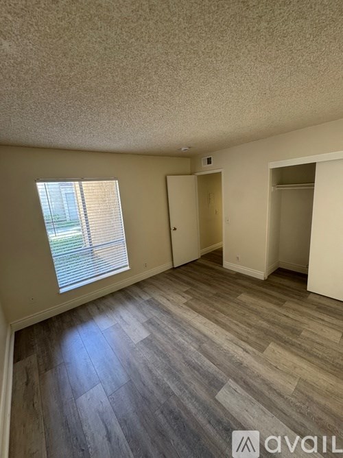 A room with a window and a wooden floor.