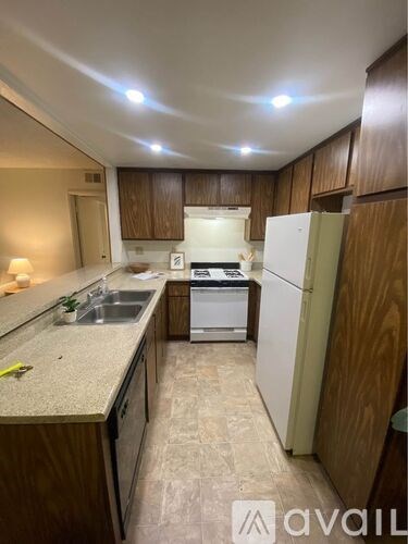 A kitchen with wooden cabinets and white appliances.