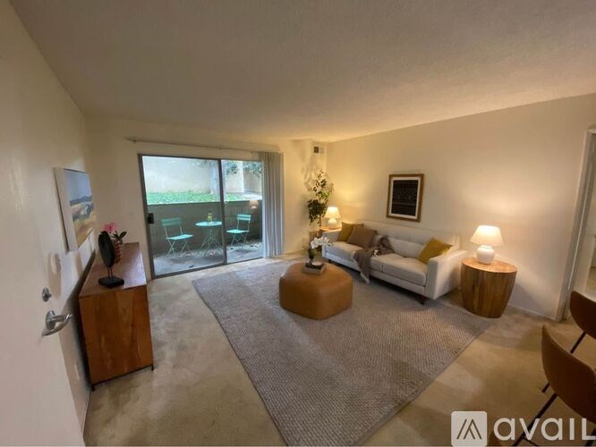 A living room with a couch, a coffee table, and a large window.