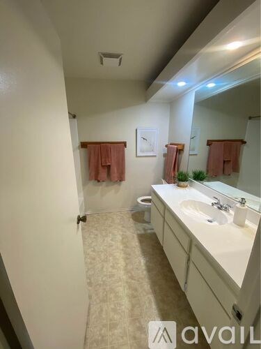 A bathroom with a sink, mirror, and towel rack.