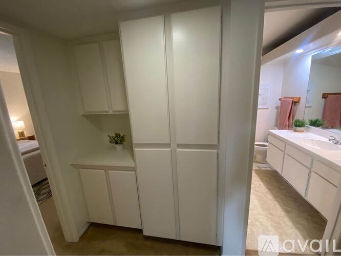 A white cabinet with a plant on top is in the foreground.