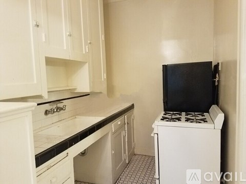 A small kitchen with a black fridge and a white stove.