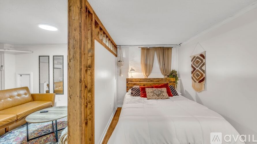 A bedroom with a white bed and a wooden headboard.