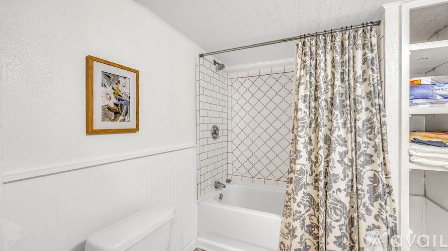 A bathroom with a white tub and a picture frame on the wall.