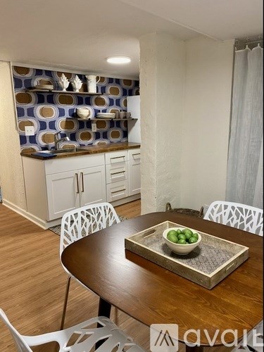 A dining table with a bowl of green grapes on it.