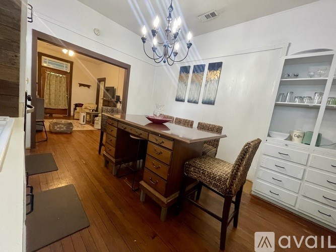 A room with a wooden floor and a chandelier hanging from the ceiling.