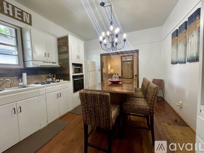 A kitchen with a dining table and chairs in the middle.