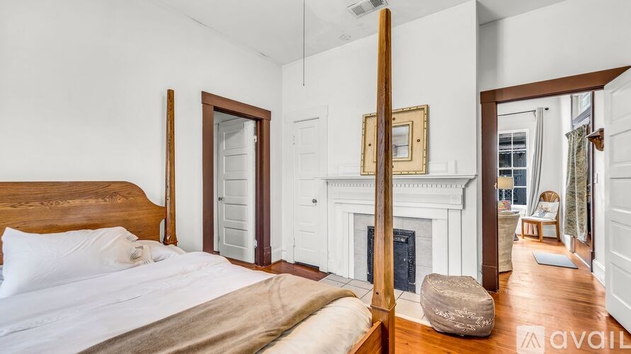 A bedroom with a large bed and a fireplace.